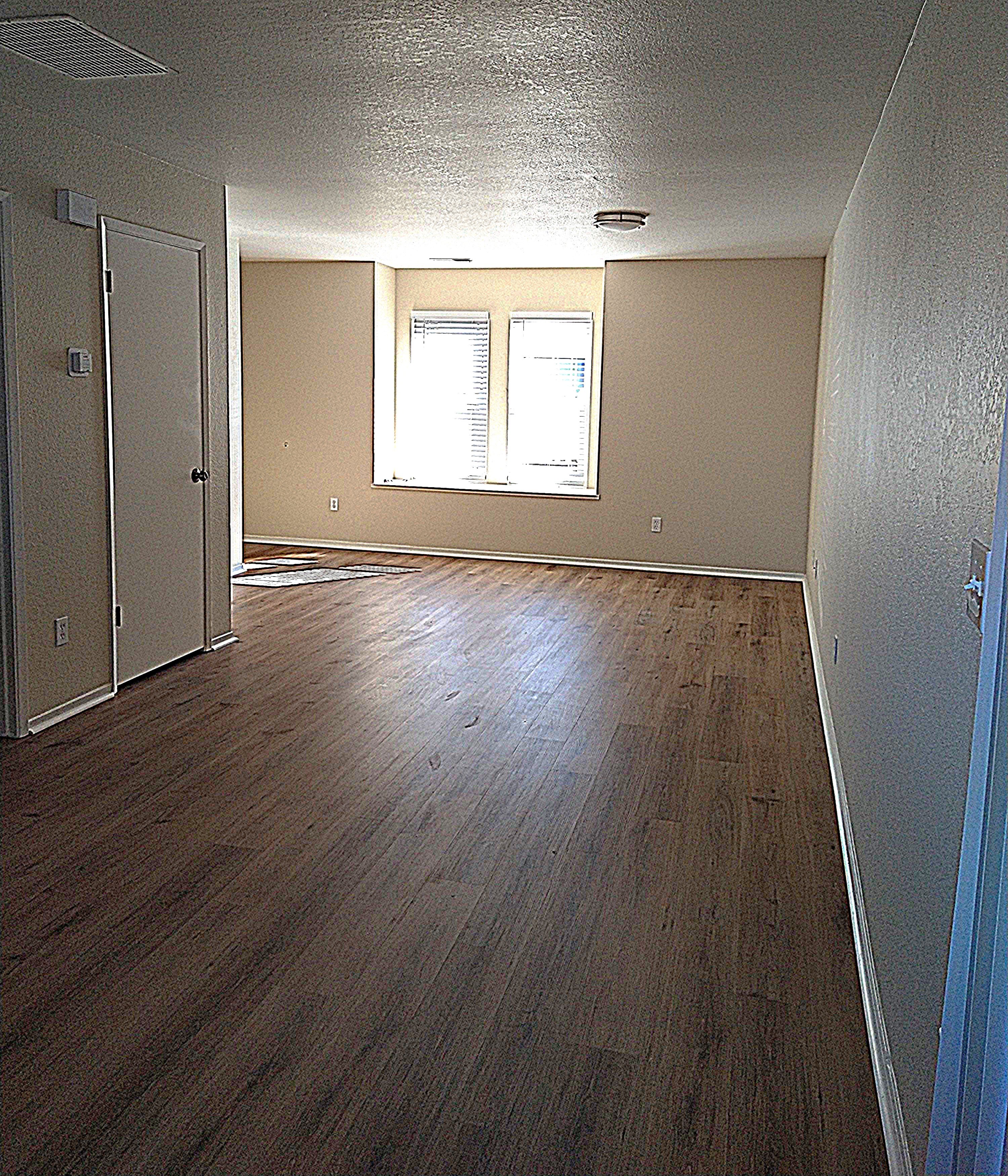 A room with wooden floors and a window.